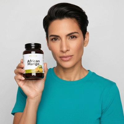 Person holding a bottle of African mango supplements with a healthy meal in the background